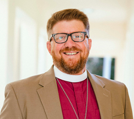 Portrait of Bishop Chip Edgar, red-haired man in glasses with beard